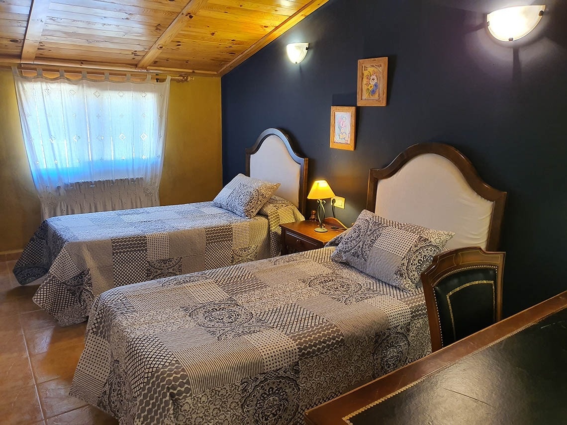 una habitación con dos camas y dos cuadros en la pared