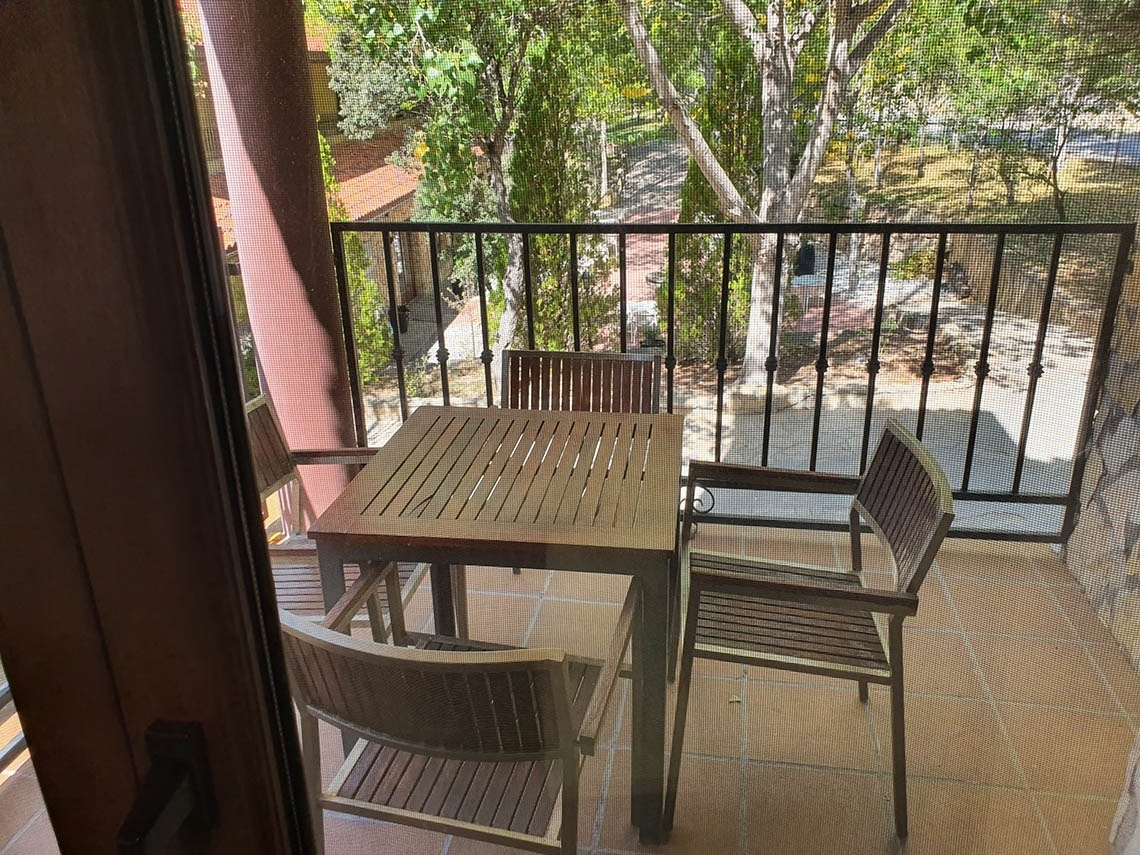 una mesa de madera y dos sillas en un balcón