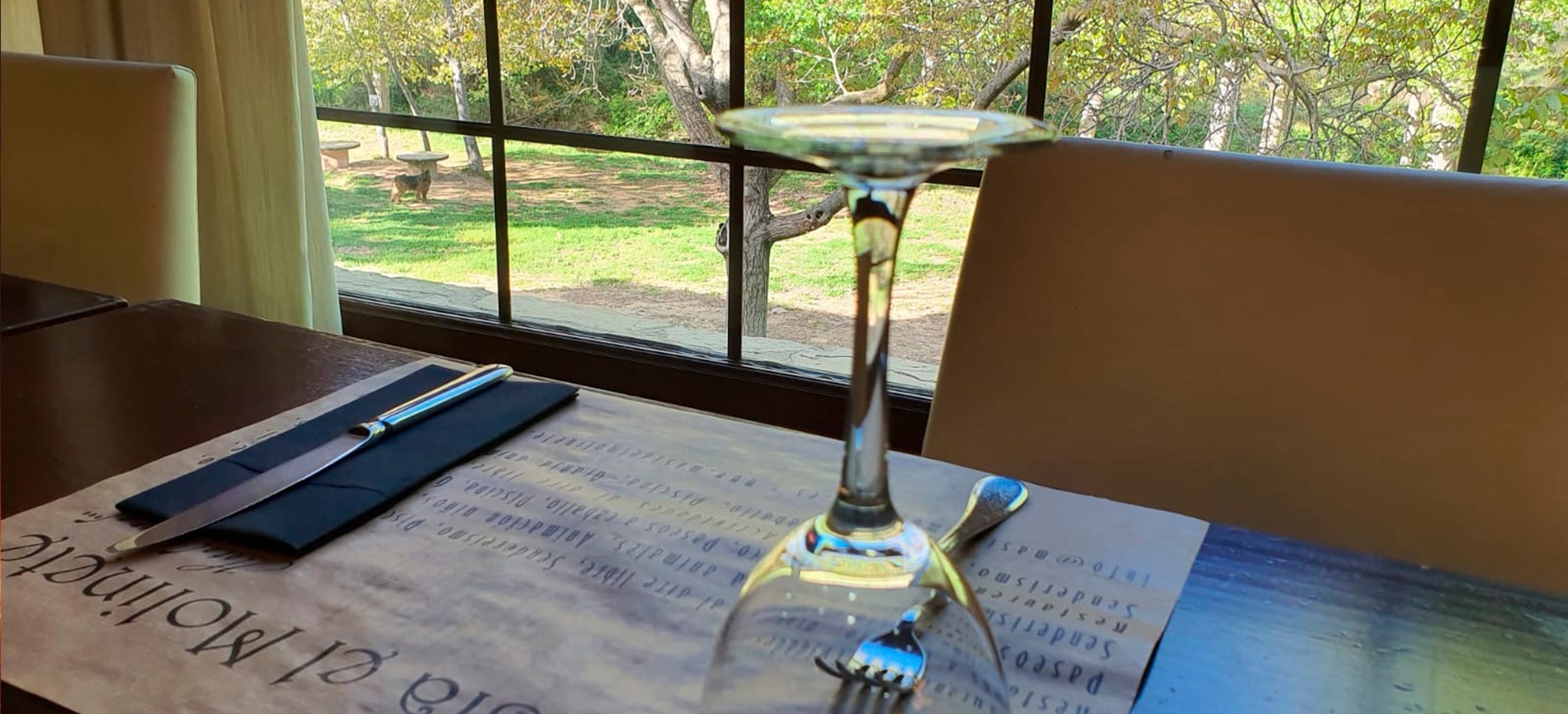una mesa con un vaso de vino y cubiertos encima de un mantel que dice pasta di molino