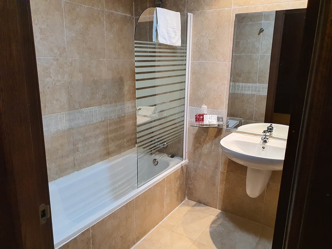 un baño con bañera lavabo y espejo