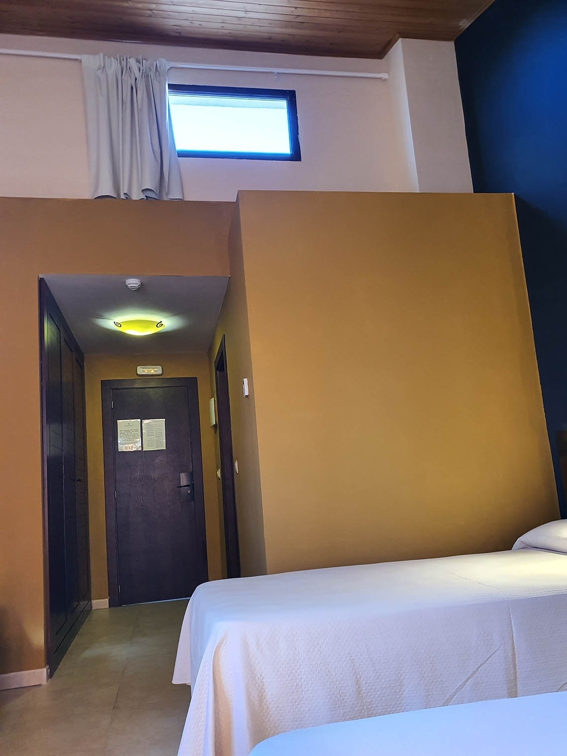 una habitación de hotel con dos camas y una ventana