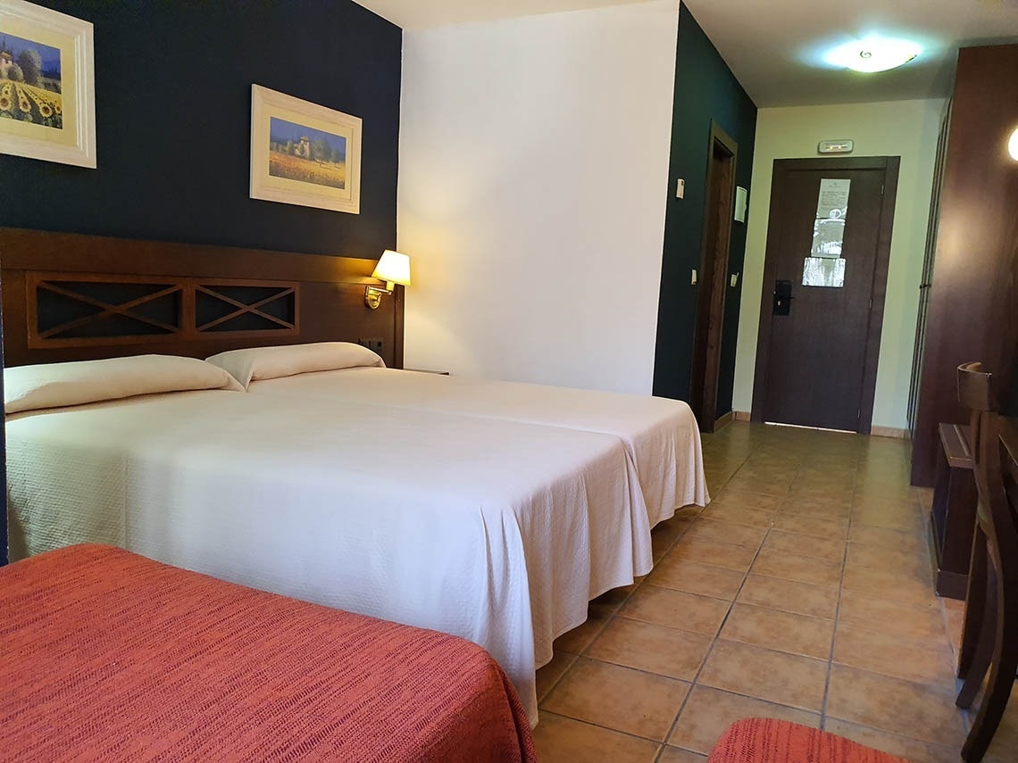 una habitación de hotel con dos camas y una puerta que dice salida