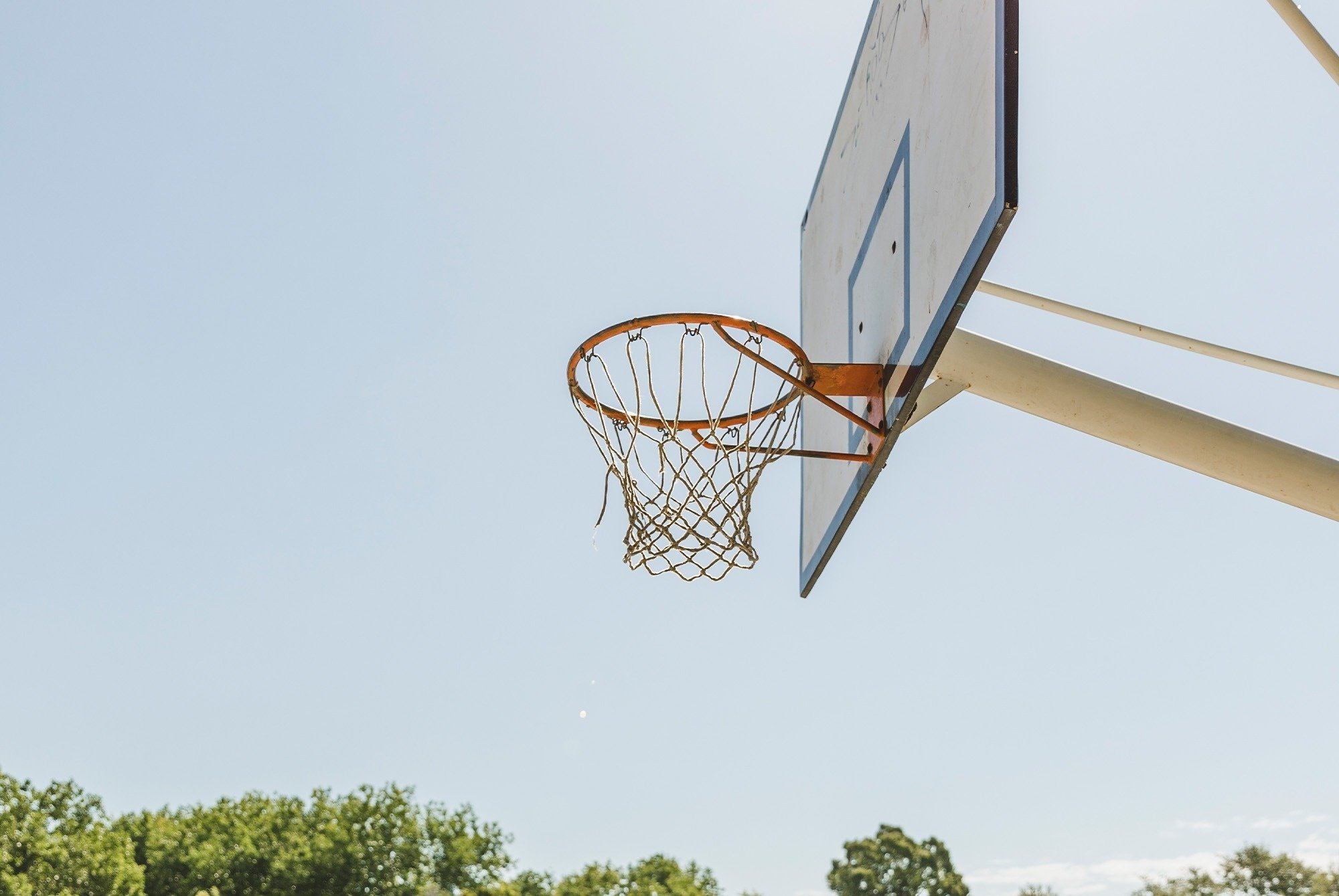 un aro de baloncesto con un cielo azul en el fondo