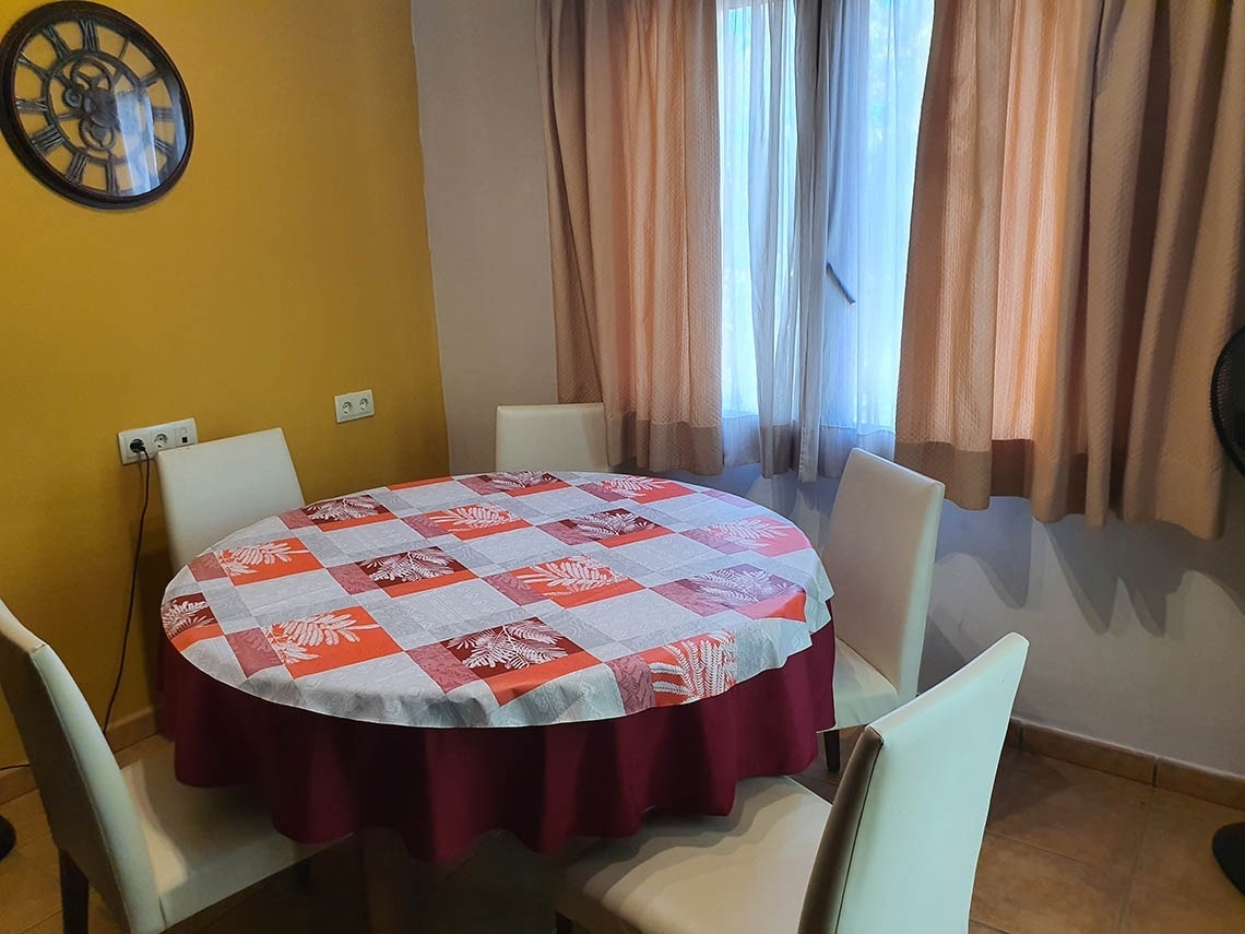 una habitación con una mesa y sillas y un reloj en la pared