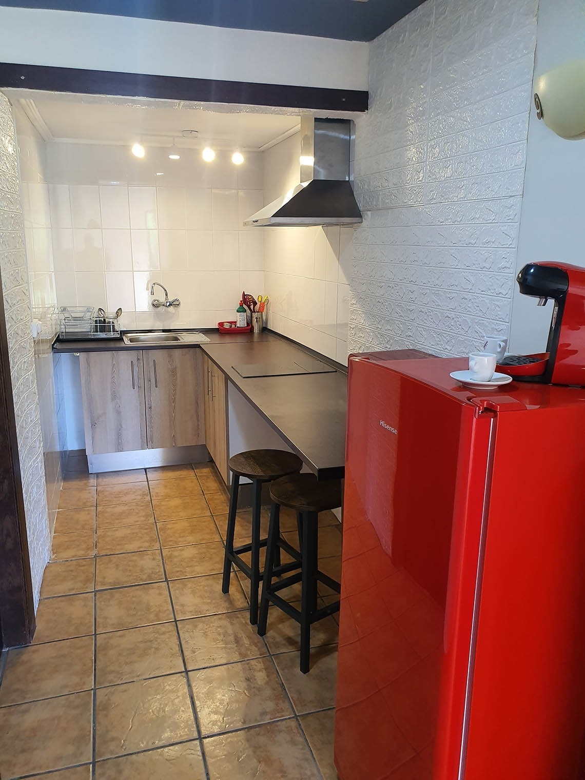 una cocina con un refrigerador rojo y una máquina de café