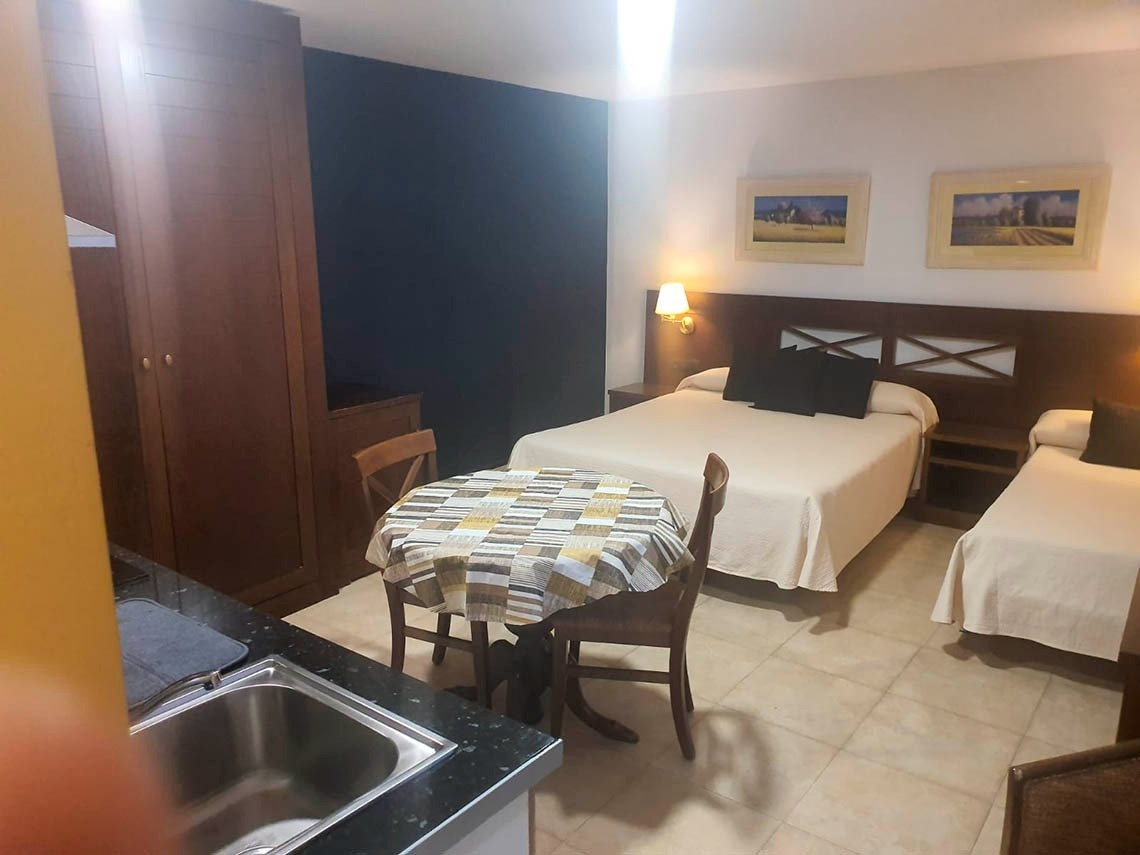 una habitación con dos camas y una mesa y sillas