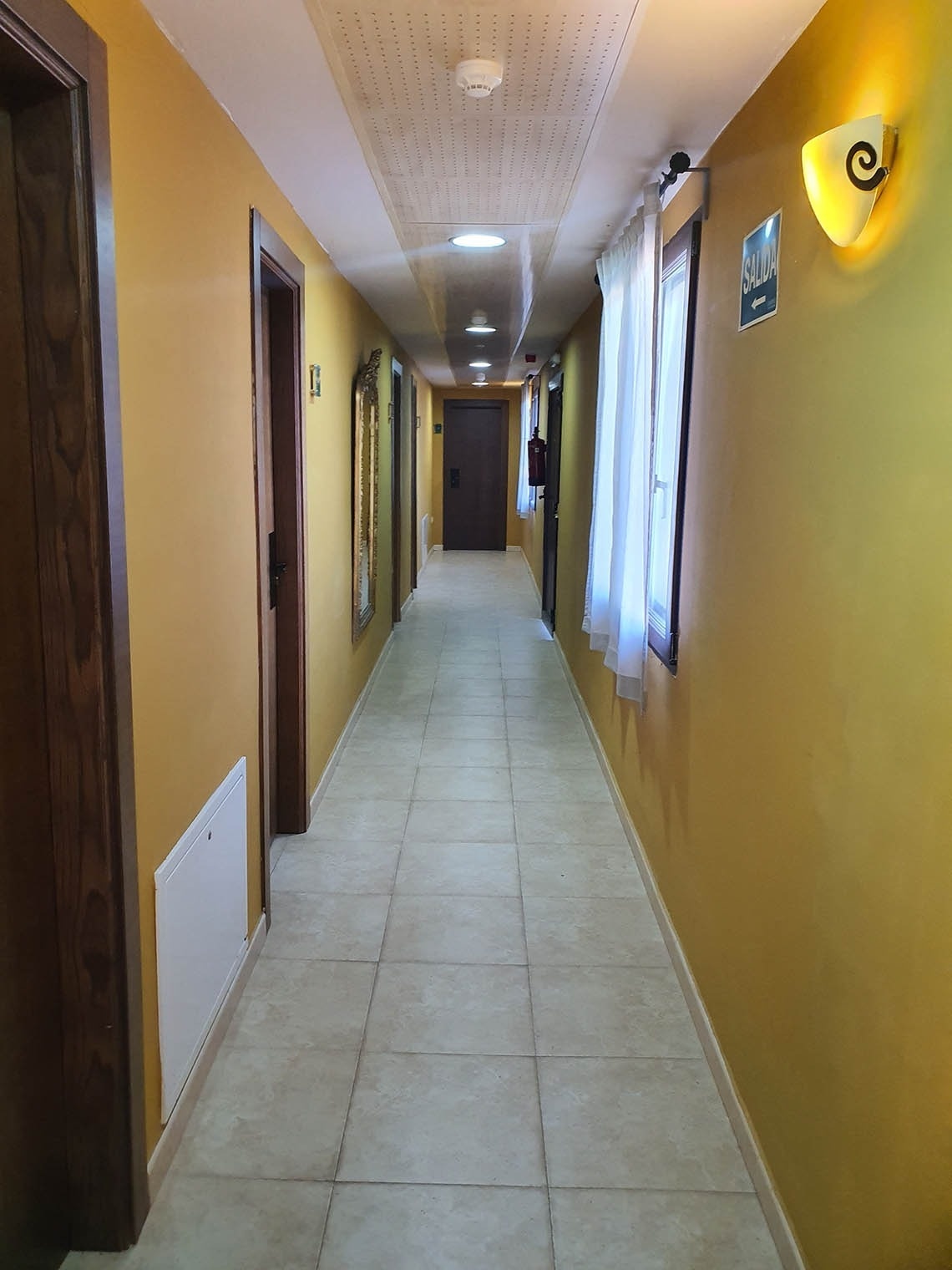 un pasillo con paredes amarillas y un letrero que dice salida