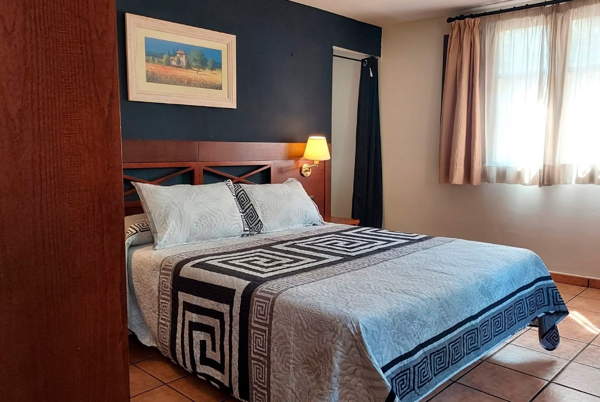 una habitación con una cama y una pintura en la pared