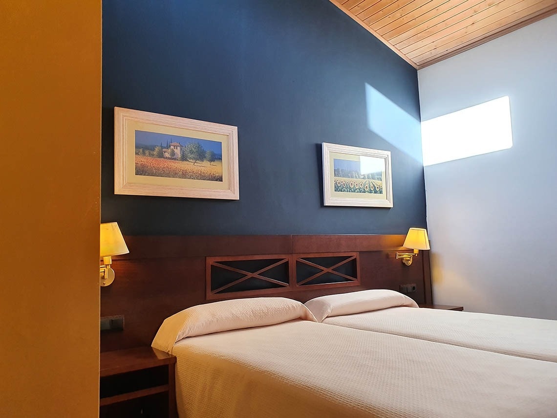 una habitación con dos camas y dos cuadros en la pared