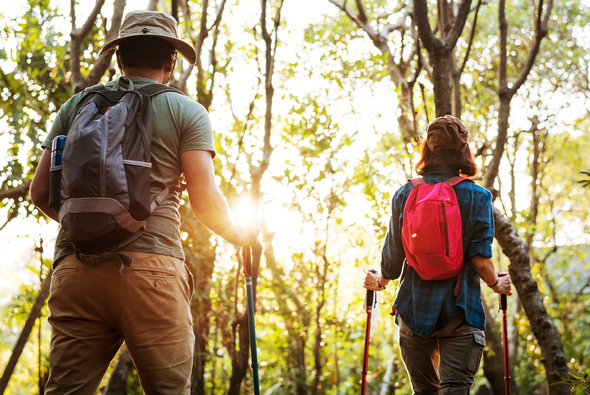 un hombre y una mujer con mochilas caminan por un bosque