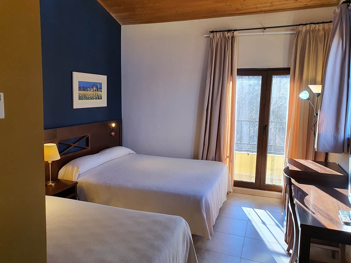 una habitación con dos camas y una ventana