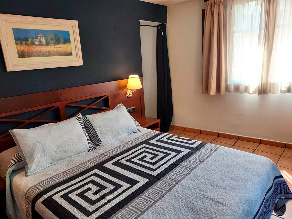 una habitación con una cama y una pintura en la pared