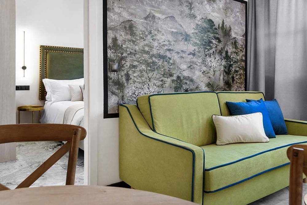 un sofá verde con almohadas blancas y azules en una habitación