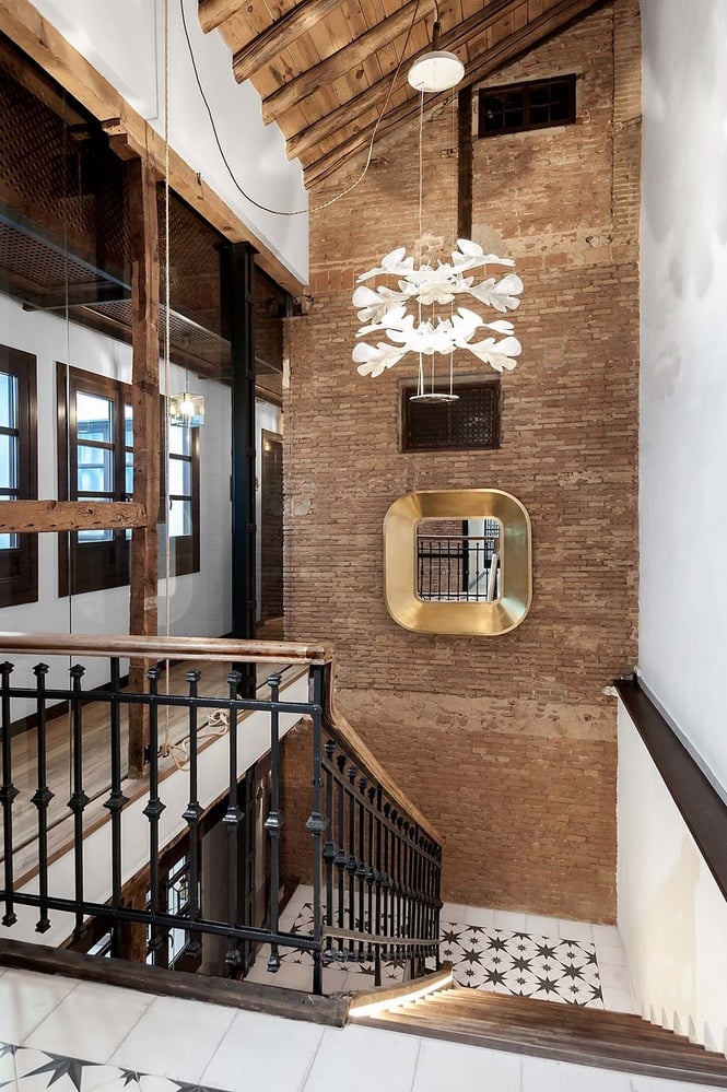 una escalera con una pared de ladrillo y un espejo