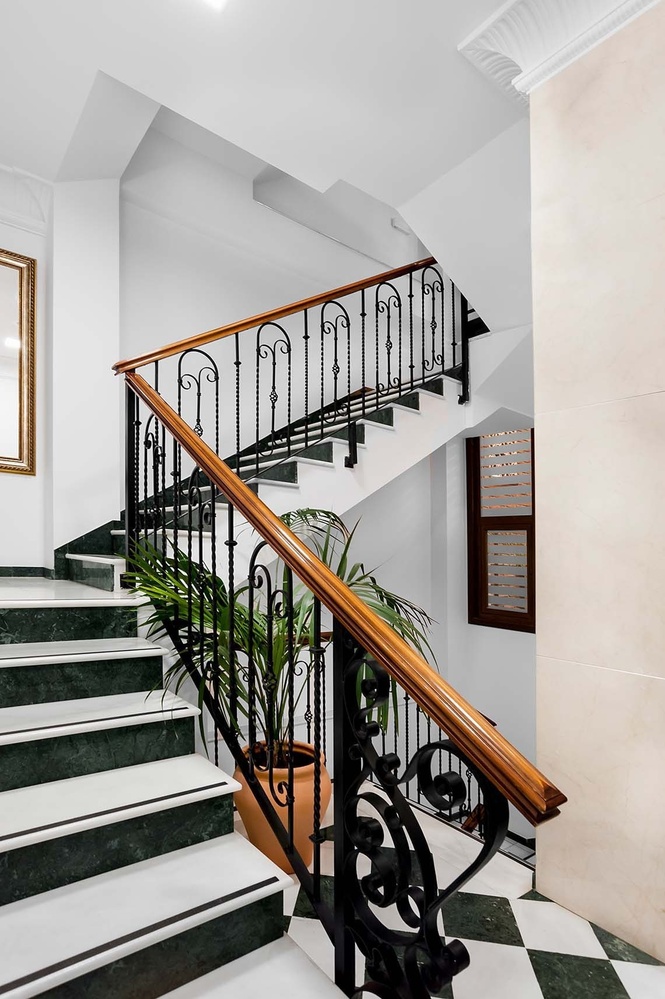 una escalera de mármol con una barandilla de hierro forjado