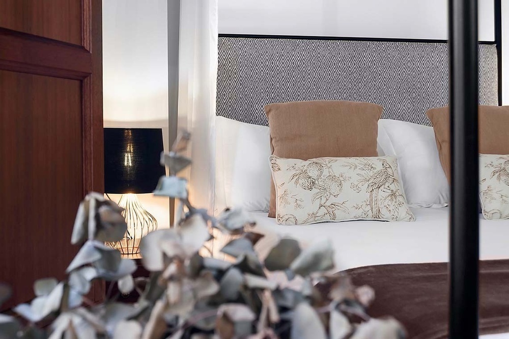 una cama con almohadas y una lámpara en una habitación