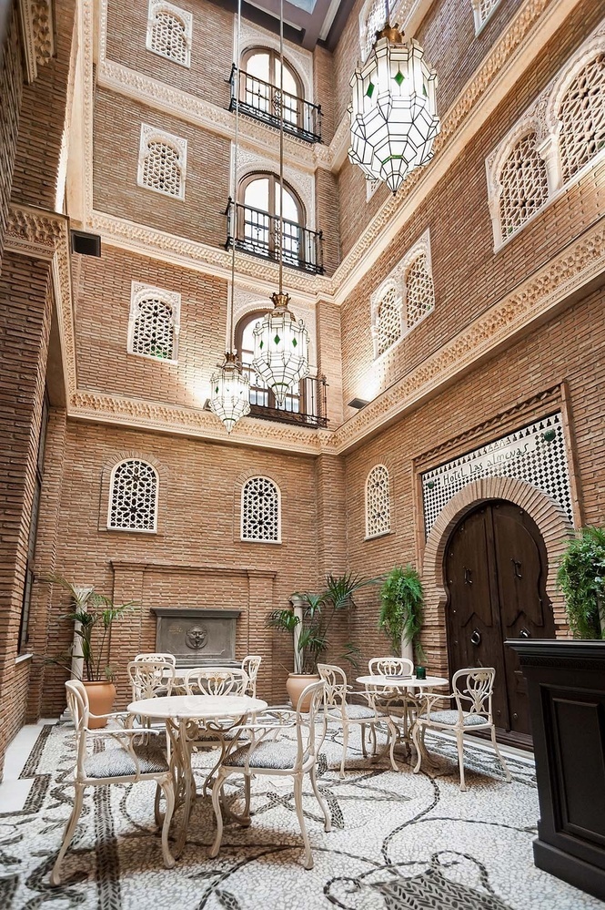 el interior de un edificio de ladrillo con mesas y sillas