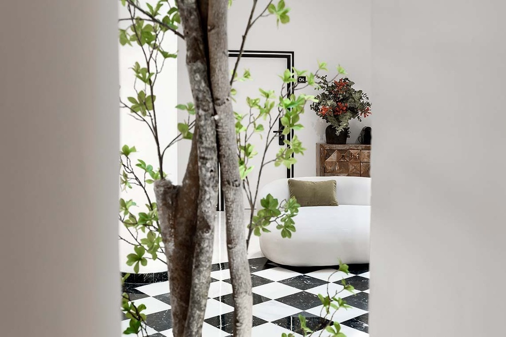 una habitación con un sofá blanco y un piso a cuadros