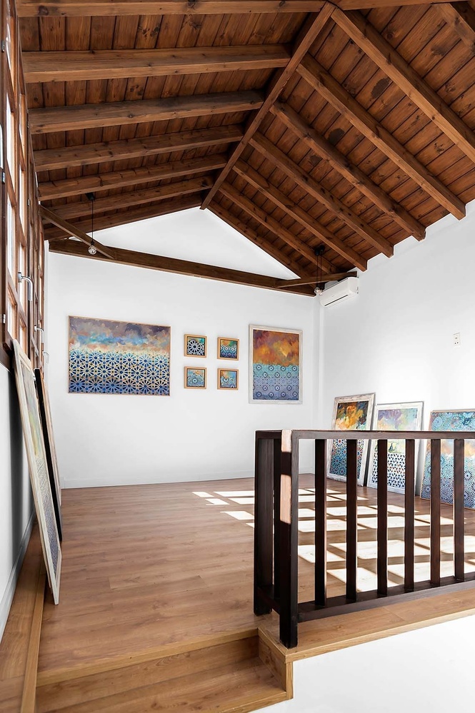 una habitación llena de cuadros y un techo de madera