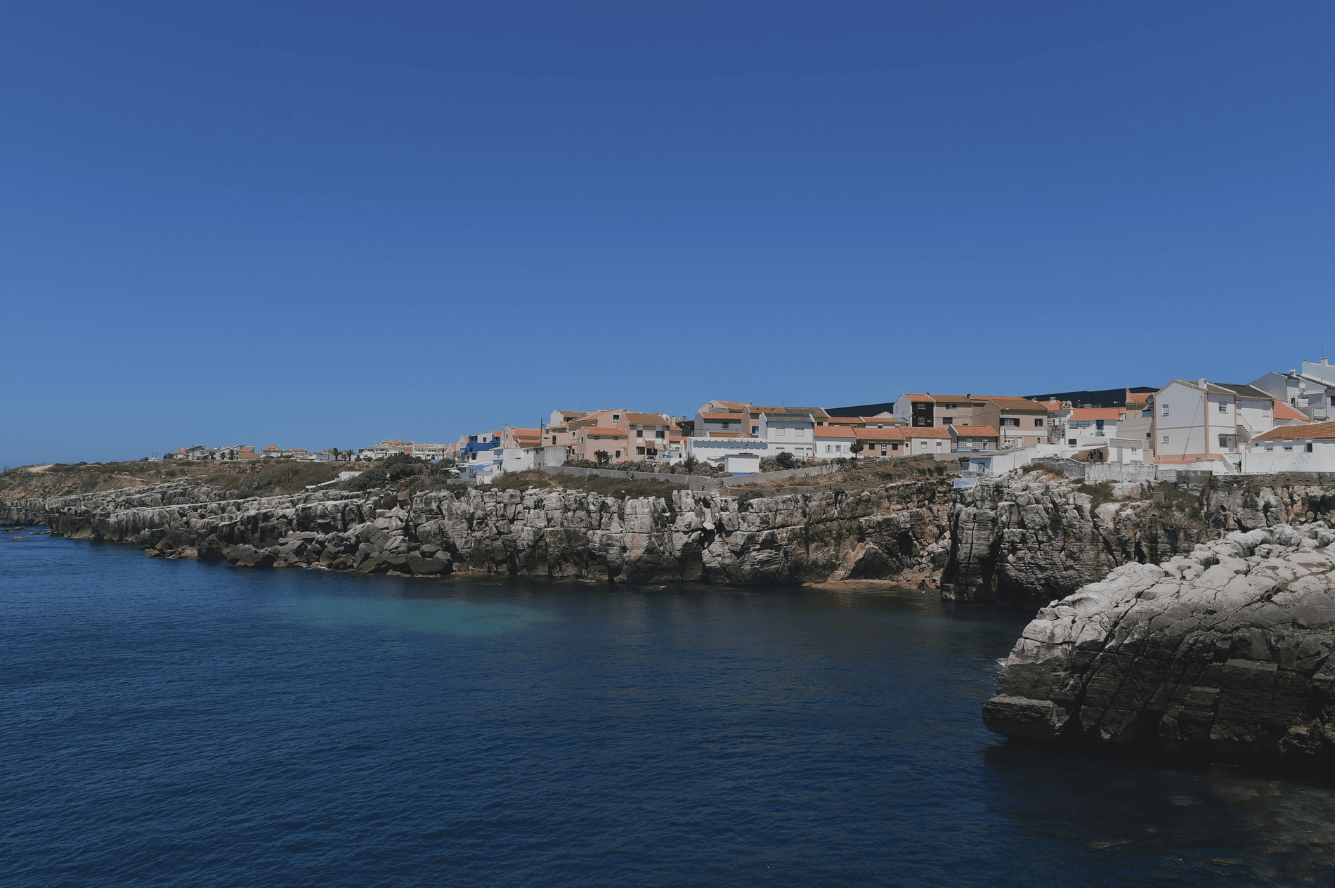 uma pequena cidade ao lado de um corpo de água