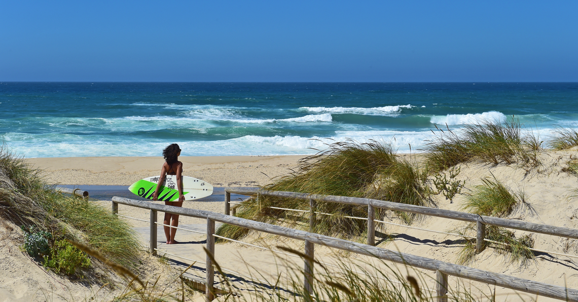 uma mulher segurando uma prancha de surf com a palavra billabong na lateral