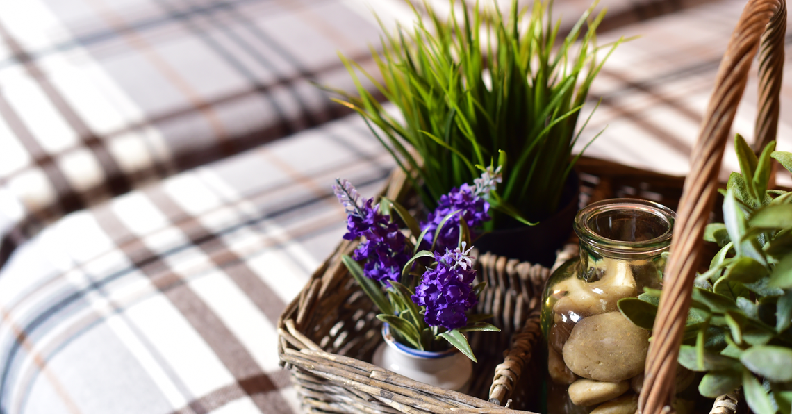 uma cesta de vime cheia de plantas e flores roxas