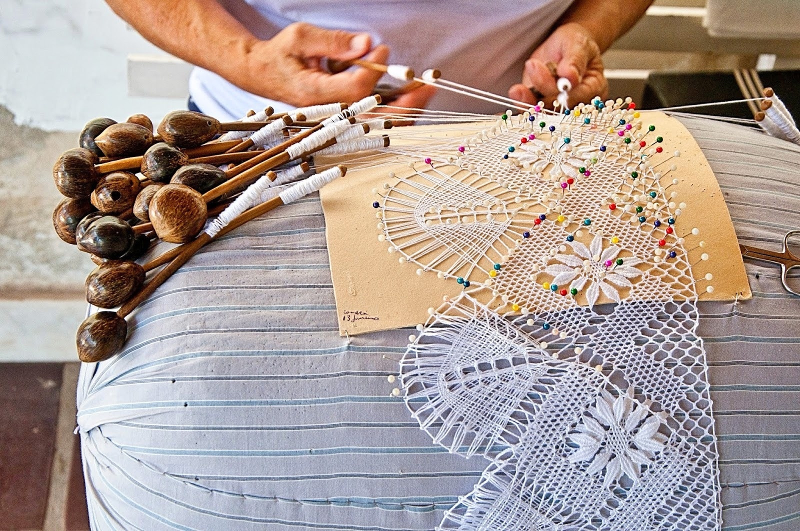 a person is working on a piece of lace