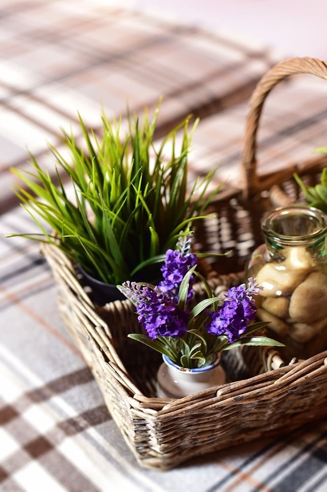 uma cesta de vime com plantas e flores roxas