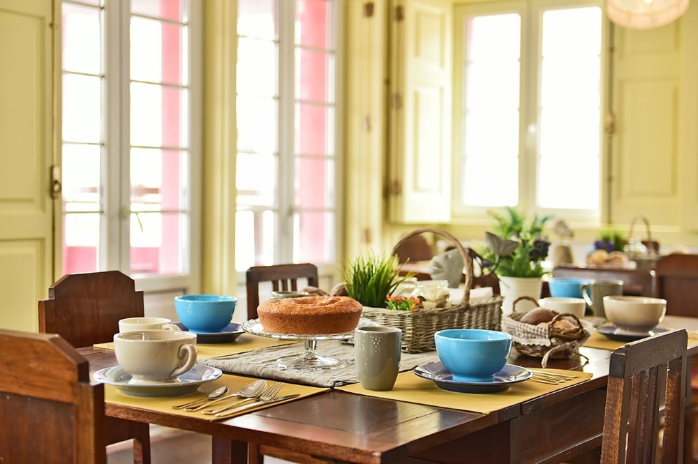 uma mesa com xícaras e pratos e um bolo em cima