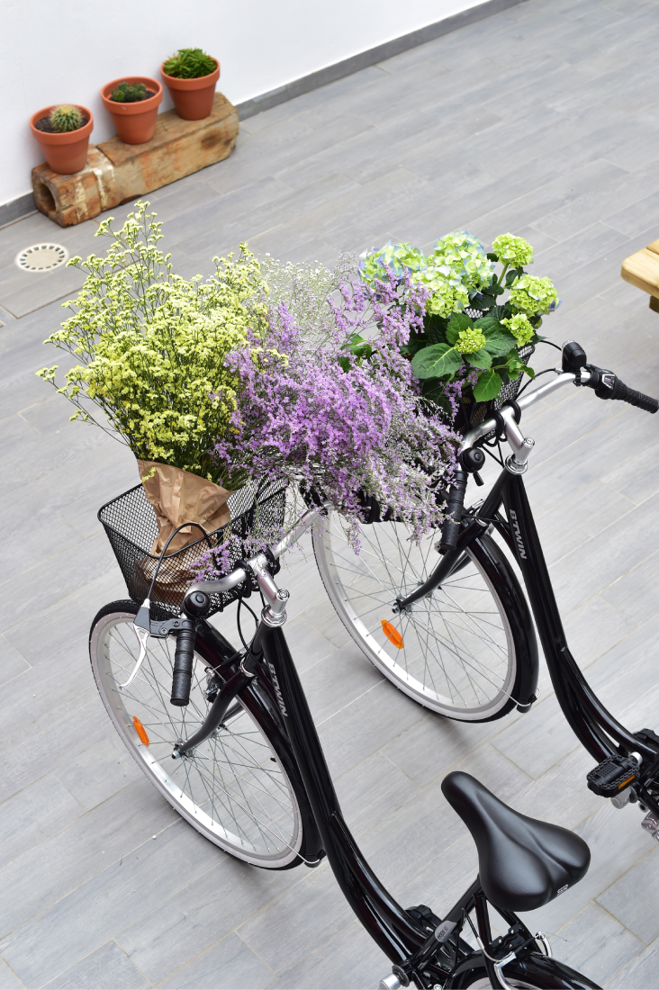 uma bicicleta preta com uma cesta cheia de flores roxas e amarelas