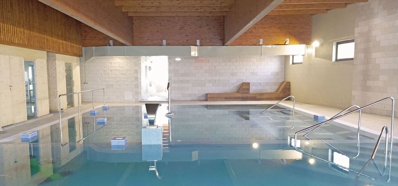 uma grande piscina coberta com água azul e escadas .