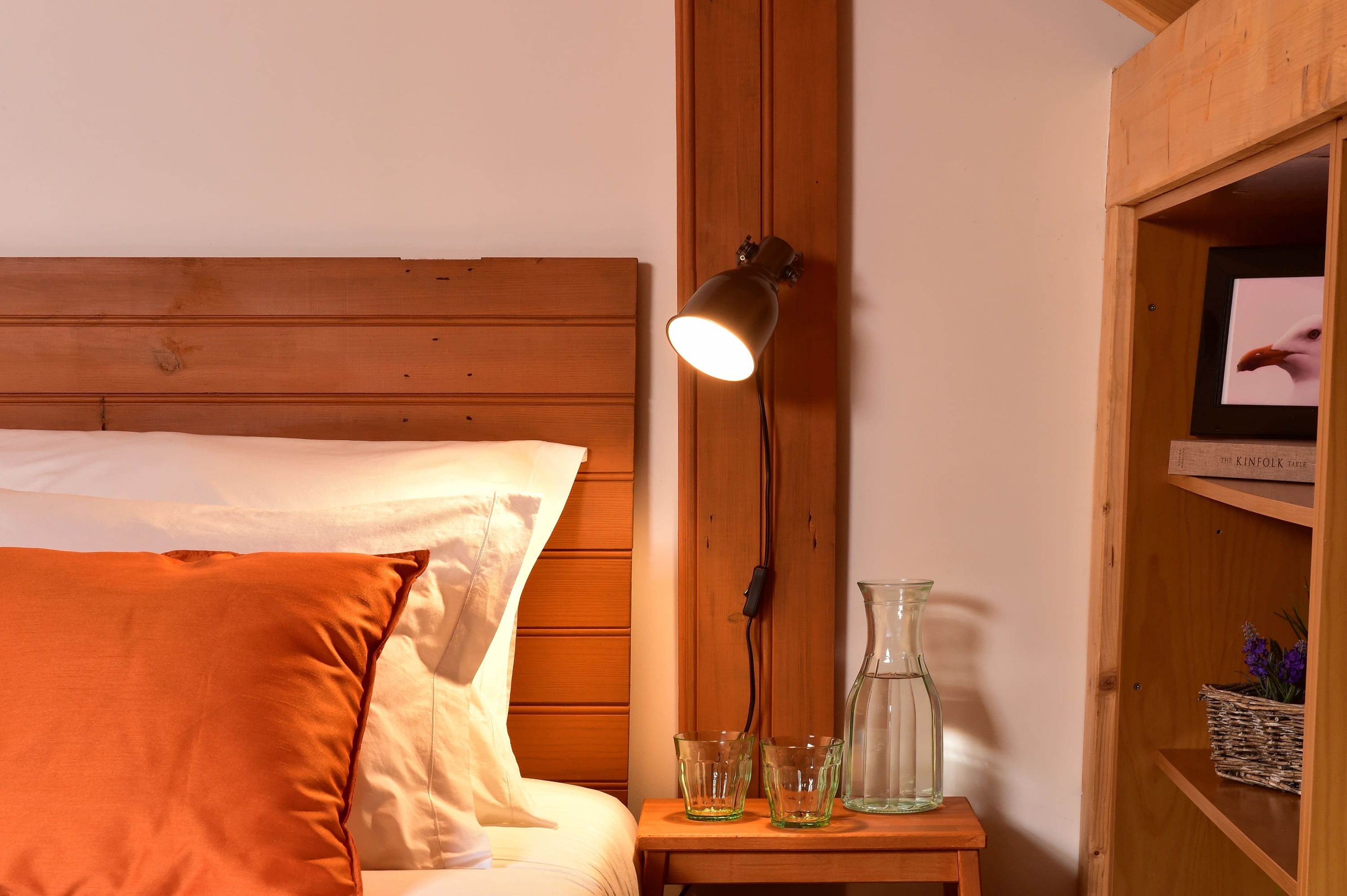 uma lâmpada está sobre uma mesa ao lado de uma cama