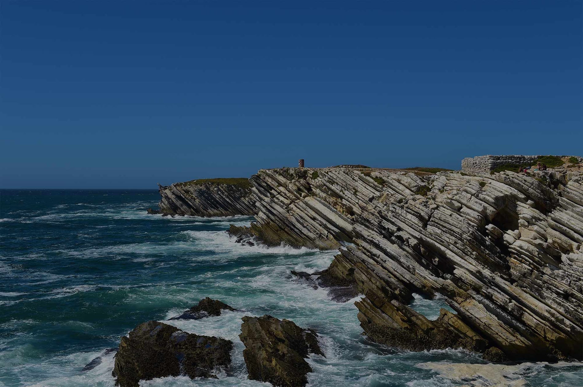 Vistas costeiras da Mercearia Dalegria em Portugal. Casas brancas e mar azul.
