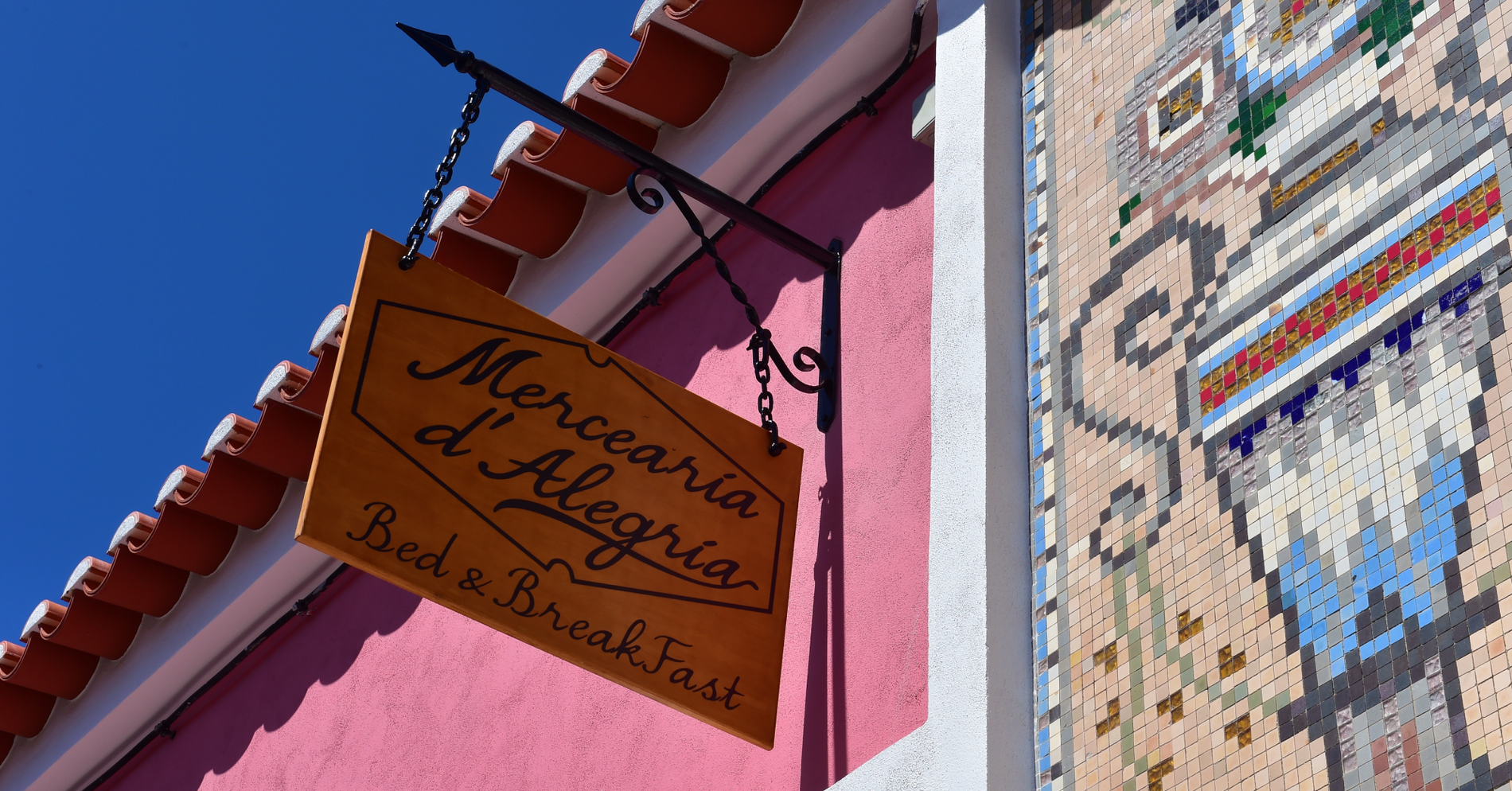 um sinal de madeira com a palavra mercearia d alegria sobre ele