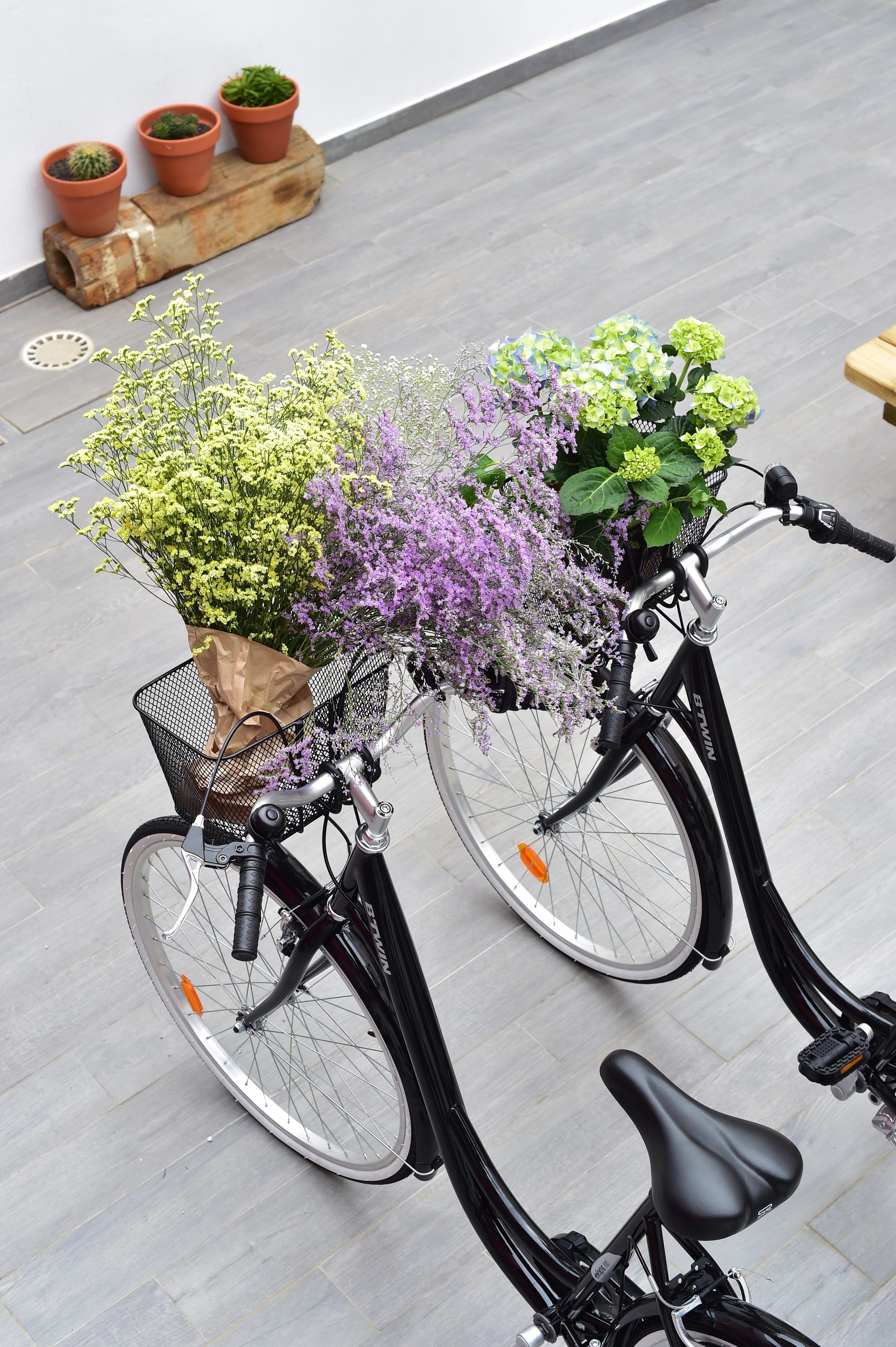 uma bicicleta preta com uma cesta cheia de flores roxas e amarelas
