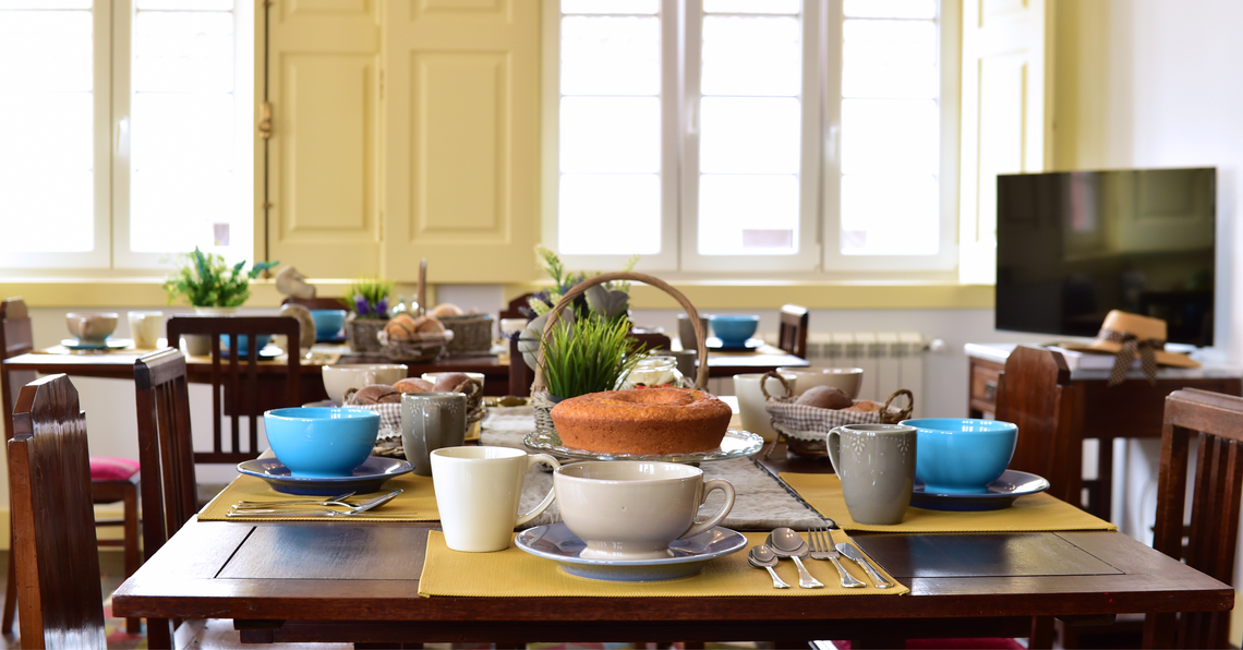 una mesa con platos y tazas y un pastel encima