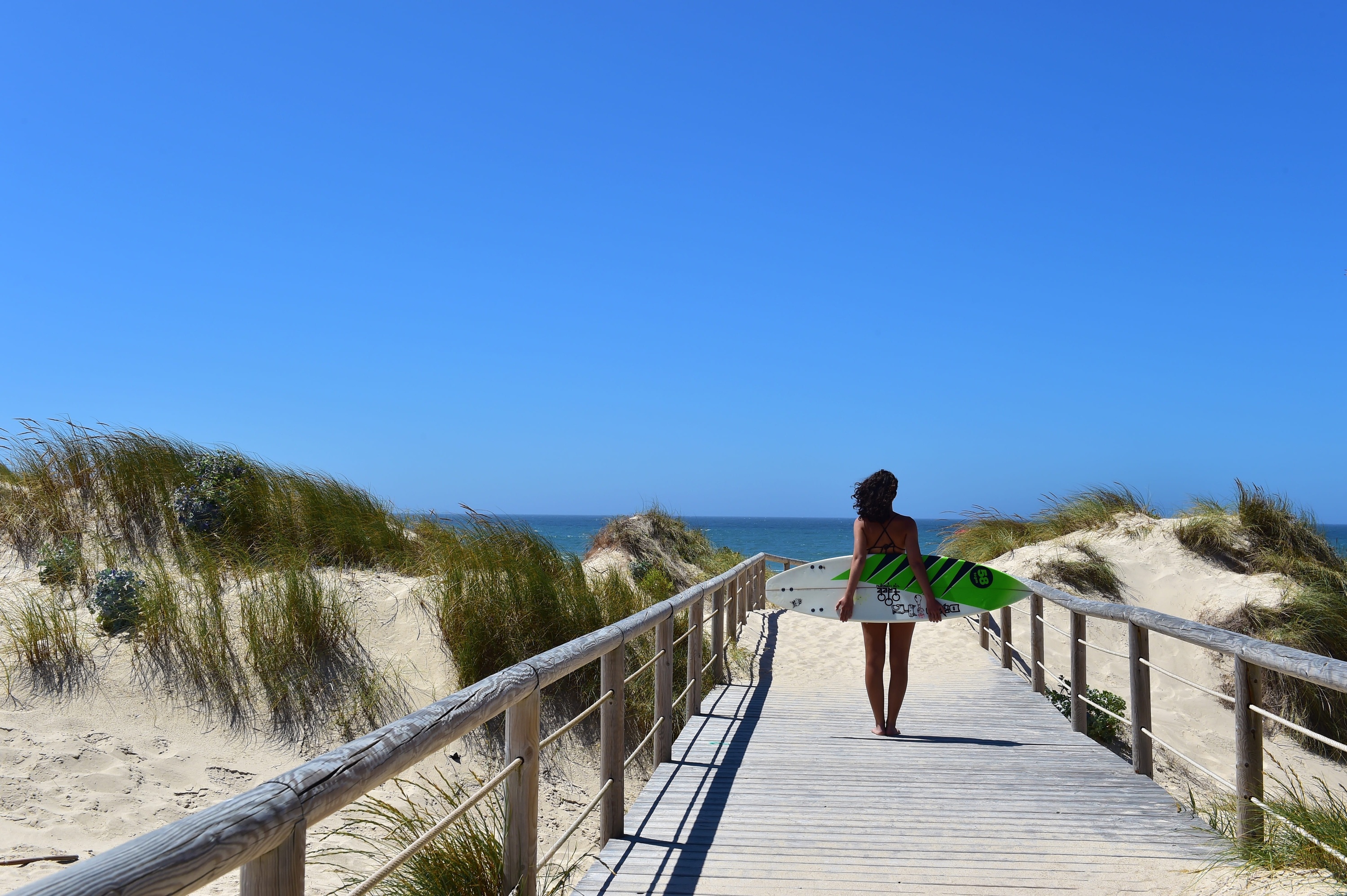 uma casa rosa com um telhado vermelho está na esquina de uma rua
