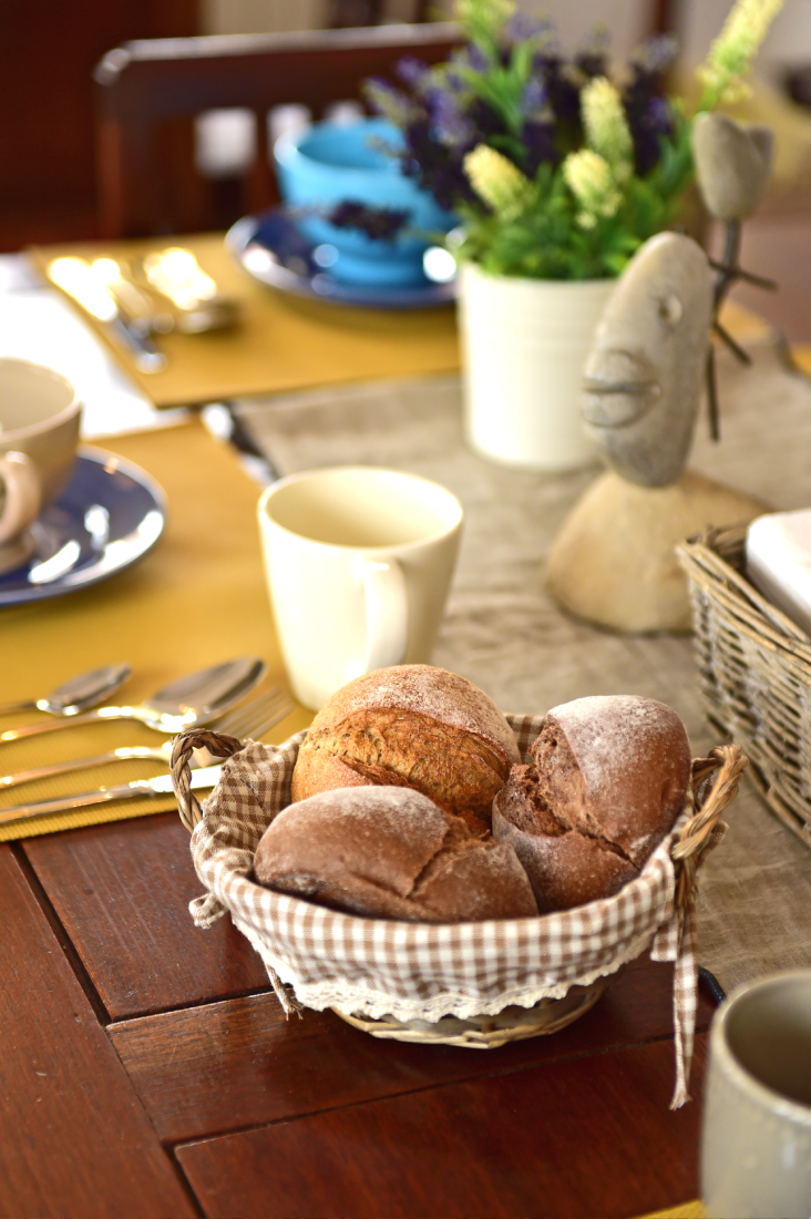 uma cesta de pão está sobre uma mesa de madeira