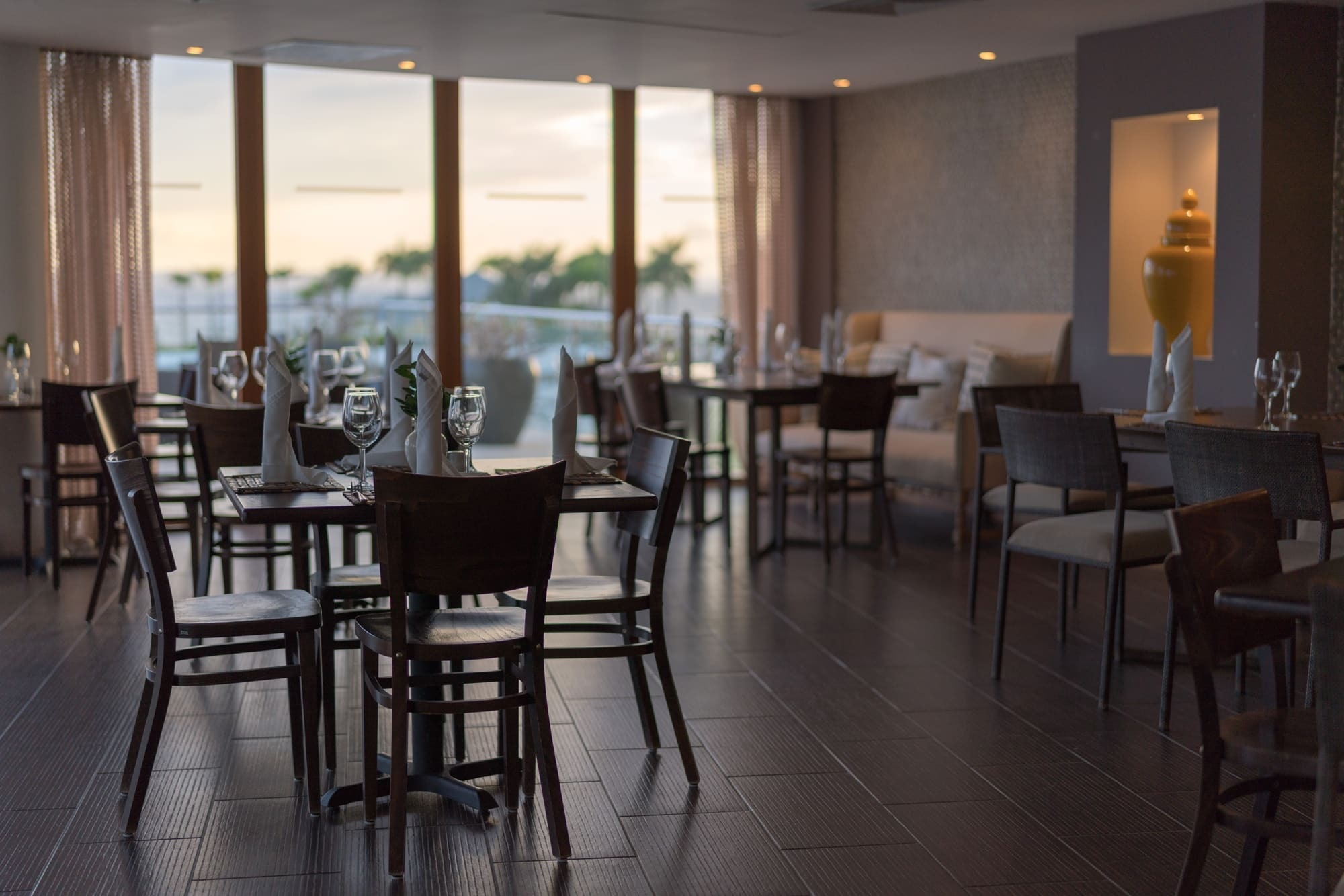 an empty restaurant with tables and chairs and a large window