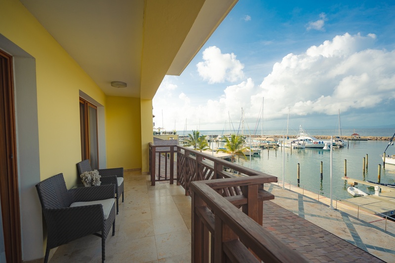 un balcón con muebles y una vista del puerto y el océano