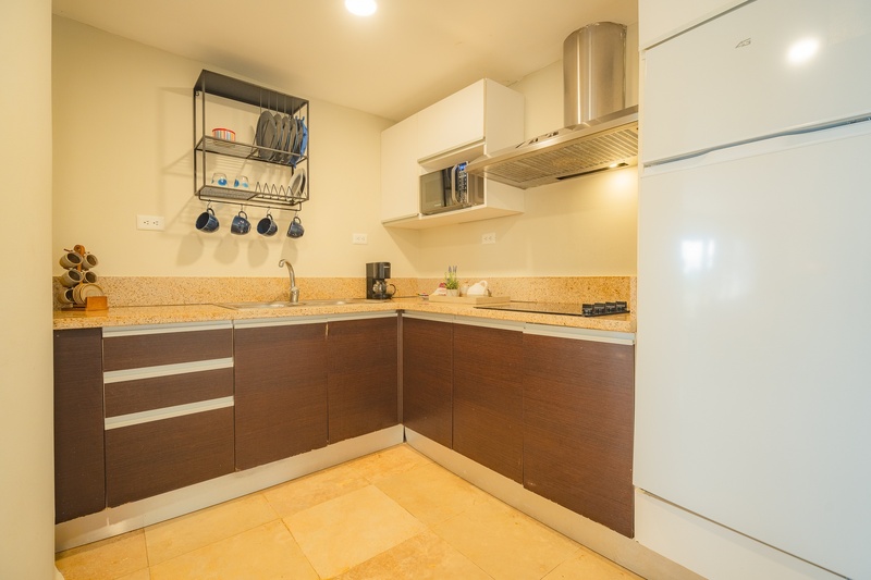 una cocina con gabinetes de madera y una nevera blanca