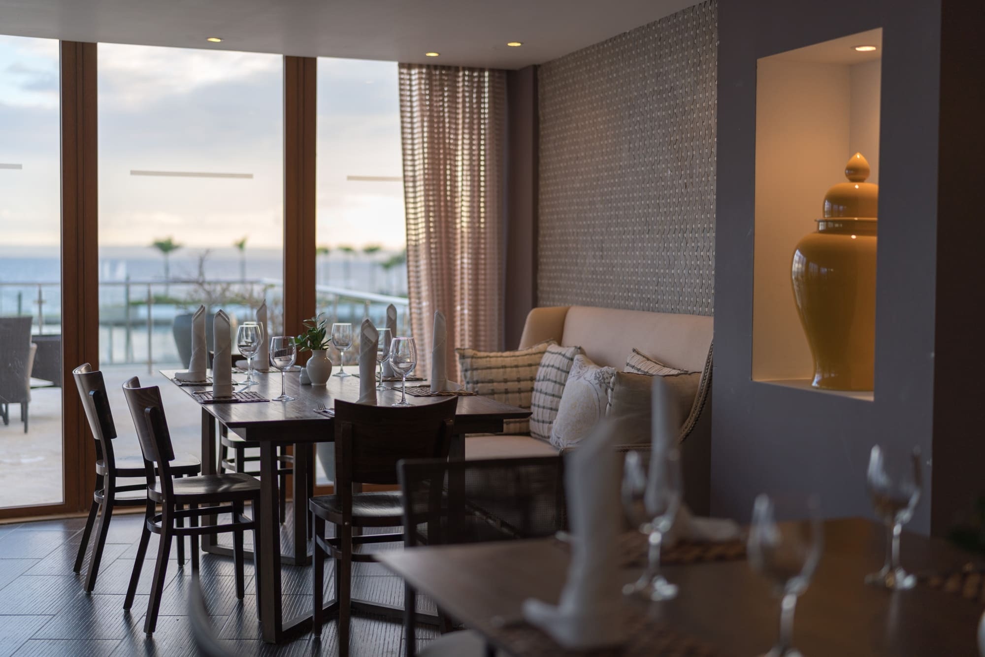 a restaurant with tables and chairs and a vase on the wall