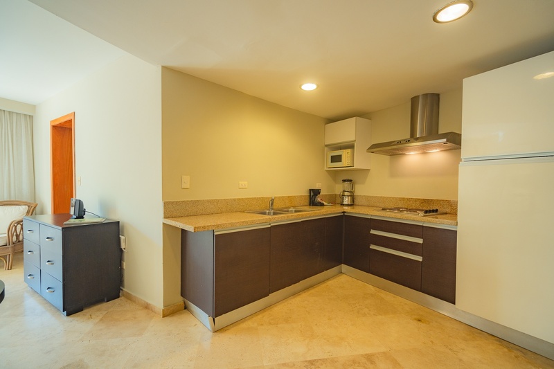 una pequeña cocina con gabinetes de madera y electrodomésticos