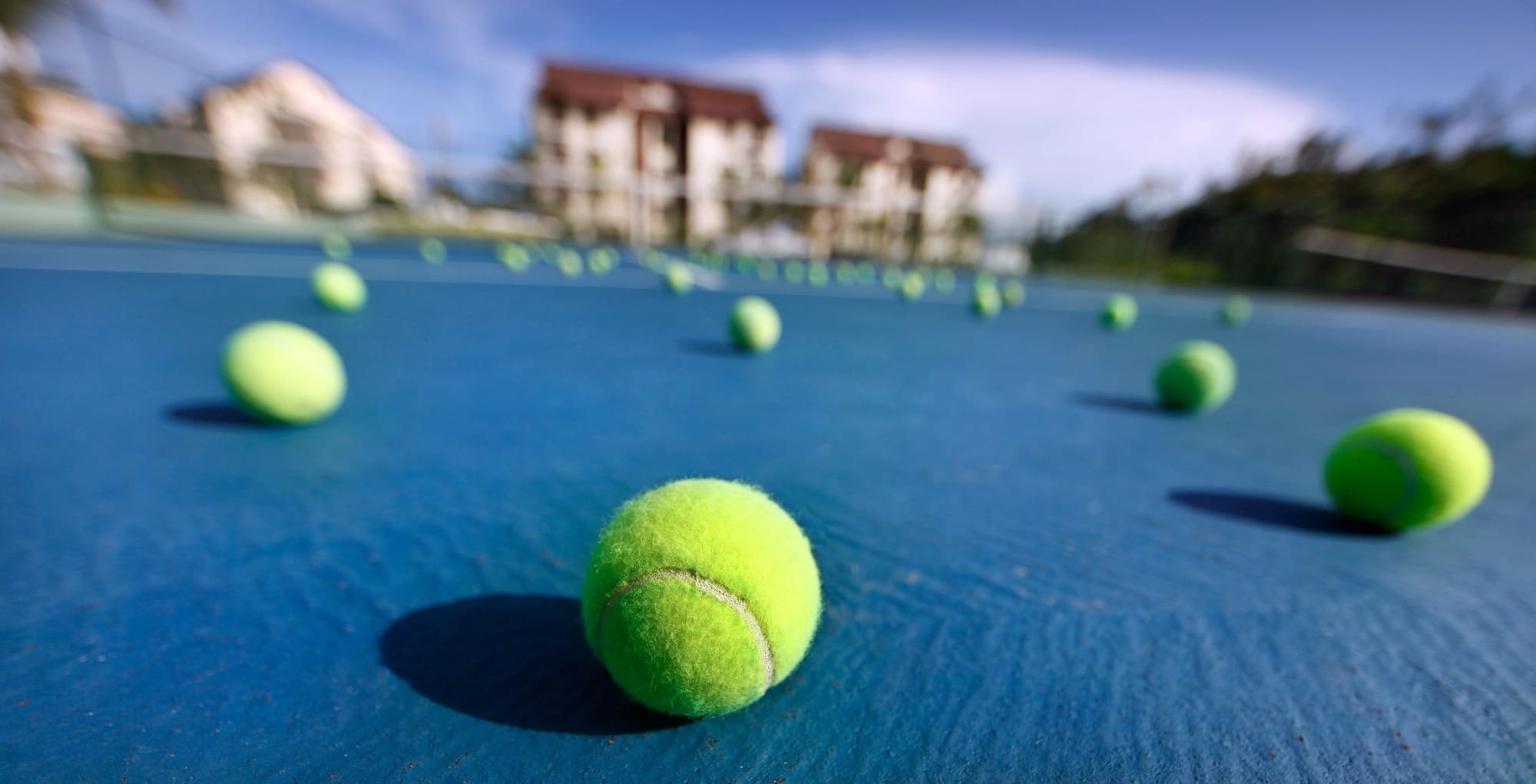 a bunch of tennis balls on a blue court