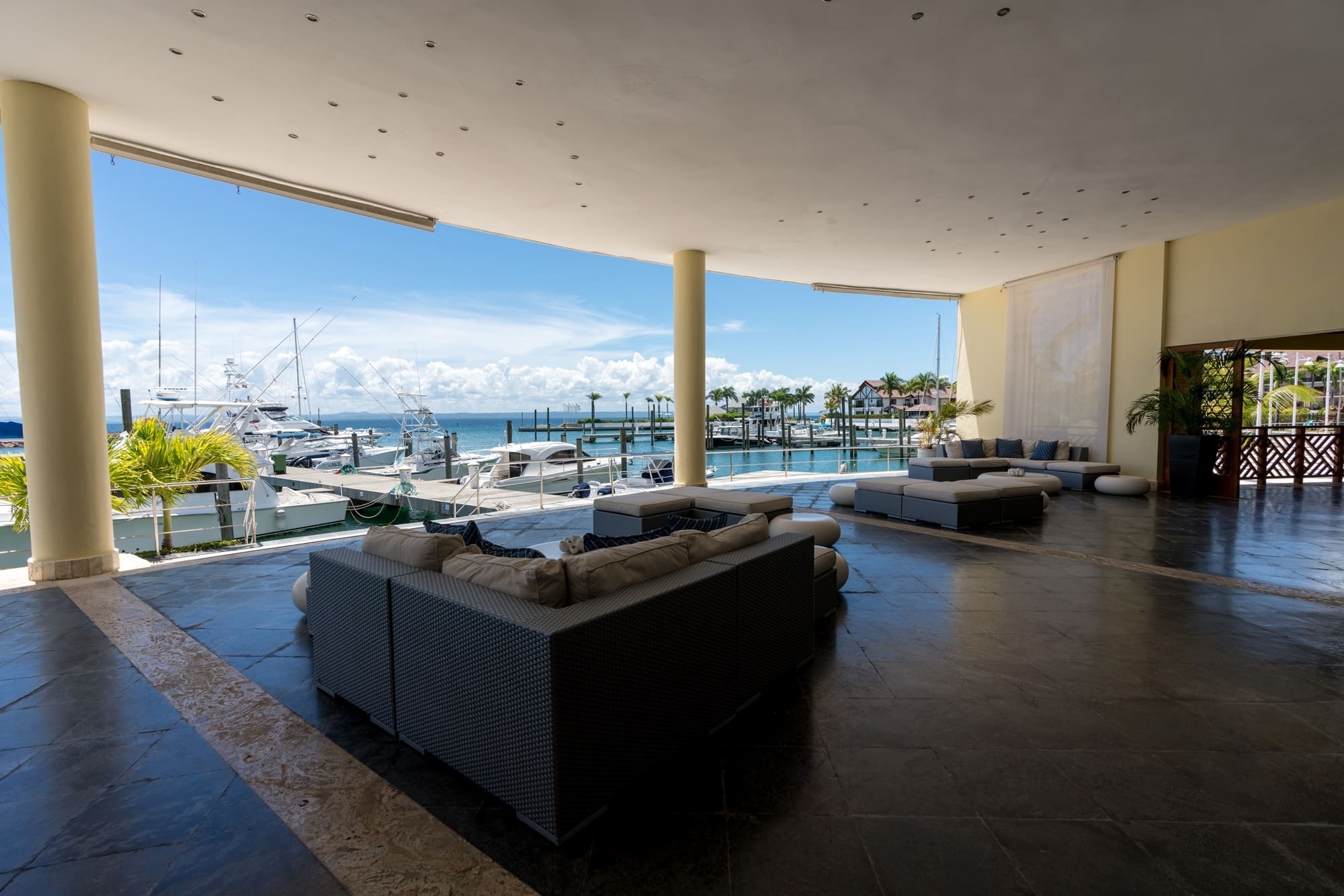 a large room with a view of a marina with boats docked
