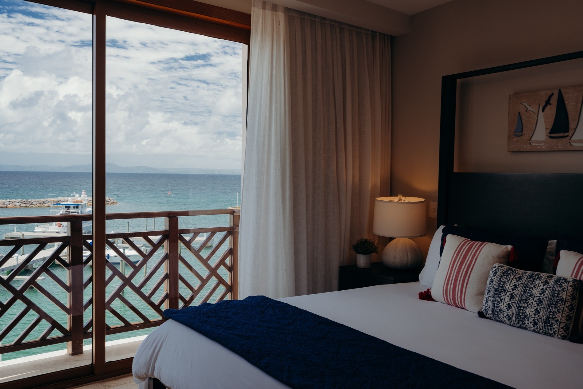 una habitación con una cama y una ventana con vista al océano