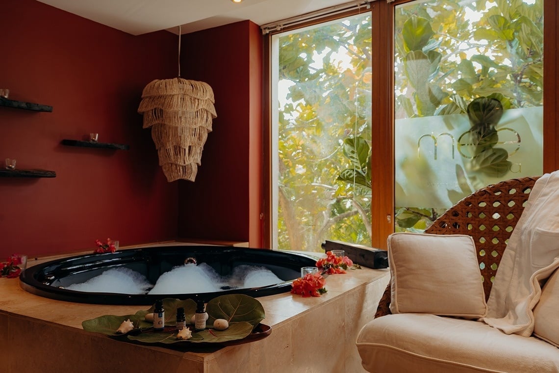 un jacuzzi en una habitación con una silla y una ventana