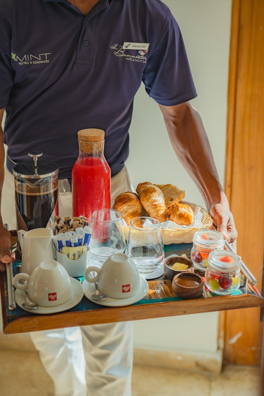 un hombre lleva una bandeja de comida con una camisa que dice mint