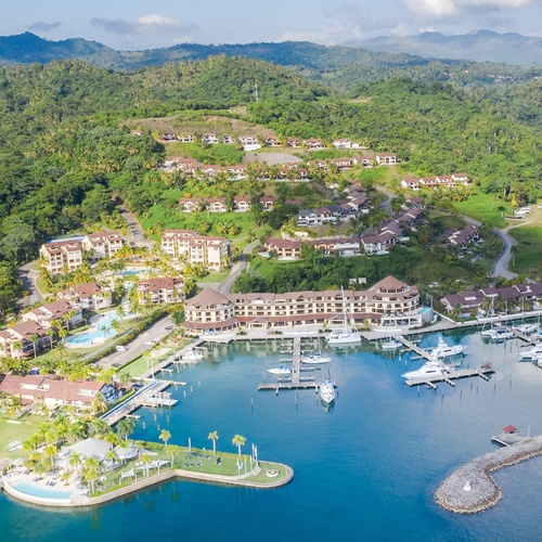 an aerial view of a resort with boats docked in the water