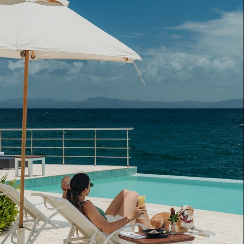 a woman laying on a beach chair with a drink in her hand